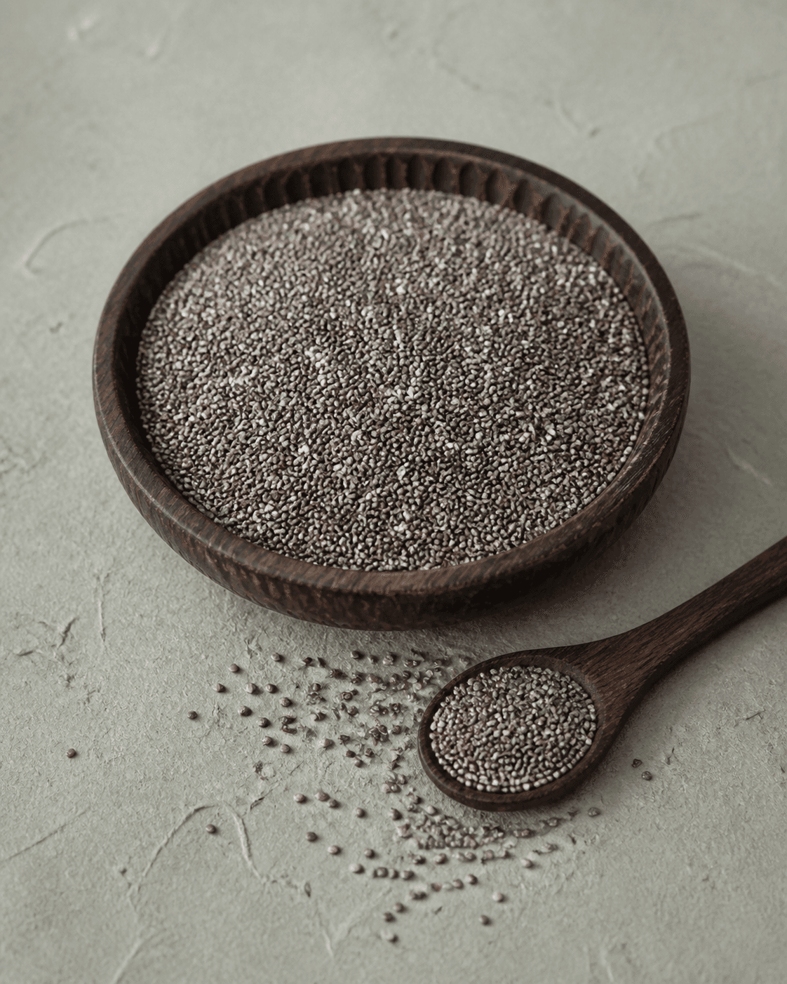Dark seeds in a carved wooden bowl
